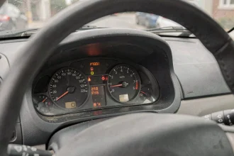 Tableau de bord original Renault Clio II avec compteur de vitesse et voyants lumineux vu depuis le siège conducteur