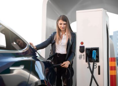 woman in formal clothes, charging an electric vehicle